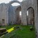 Grass growing on the floor of stone medieval ruins with high arches